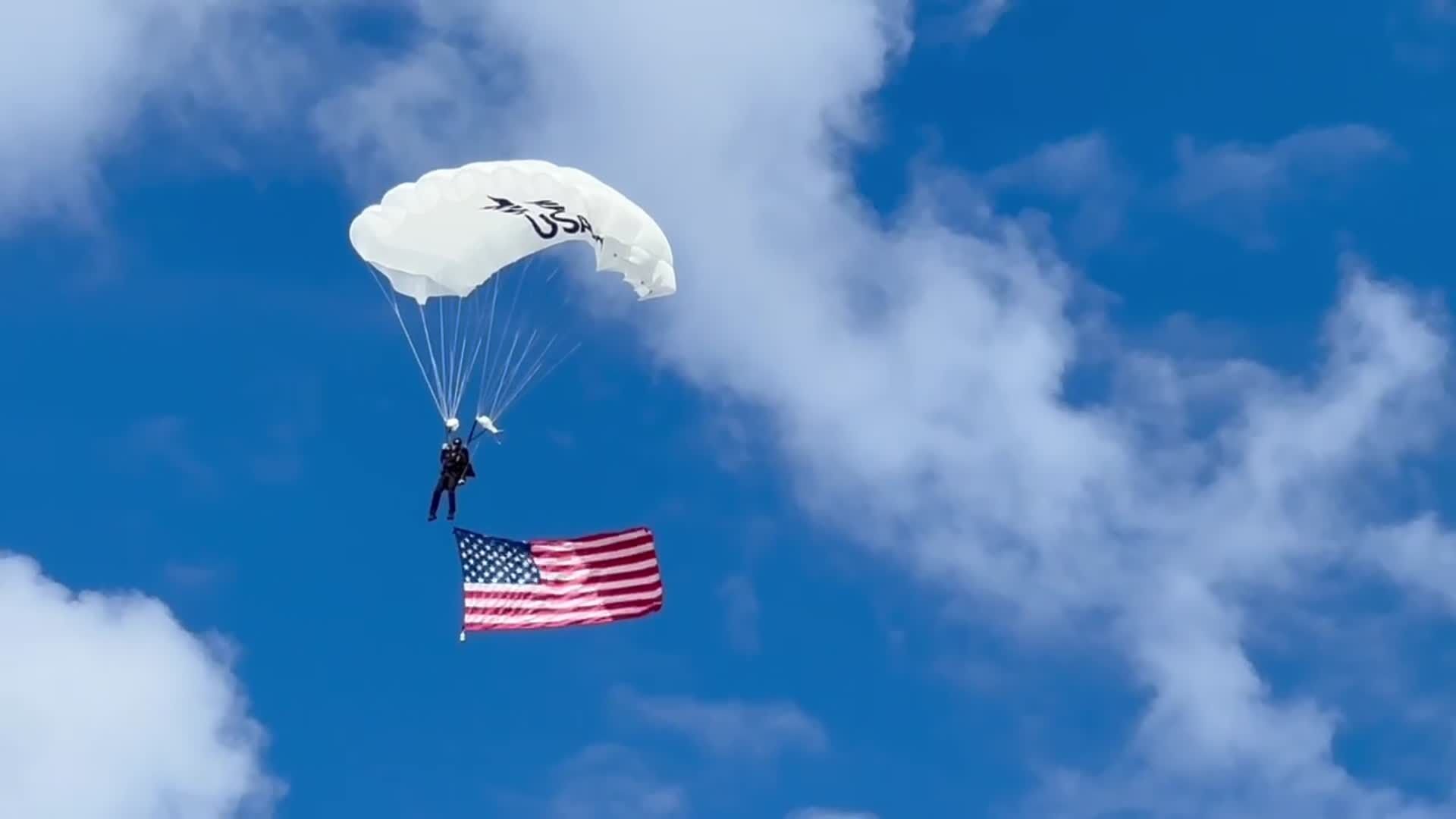 A skydiver brings the American flag into Bank of America Stadium on Sunday